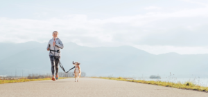 Eine Frau joggt mit einem Hund.