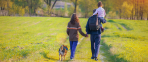 Eine Familie, die mit ihrem Hund spazieren geht.